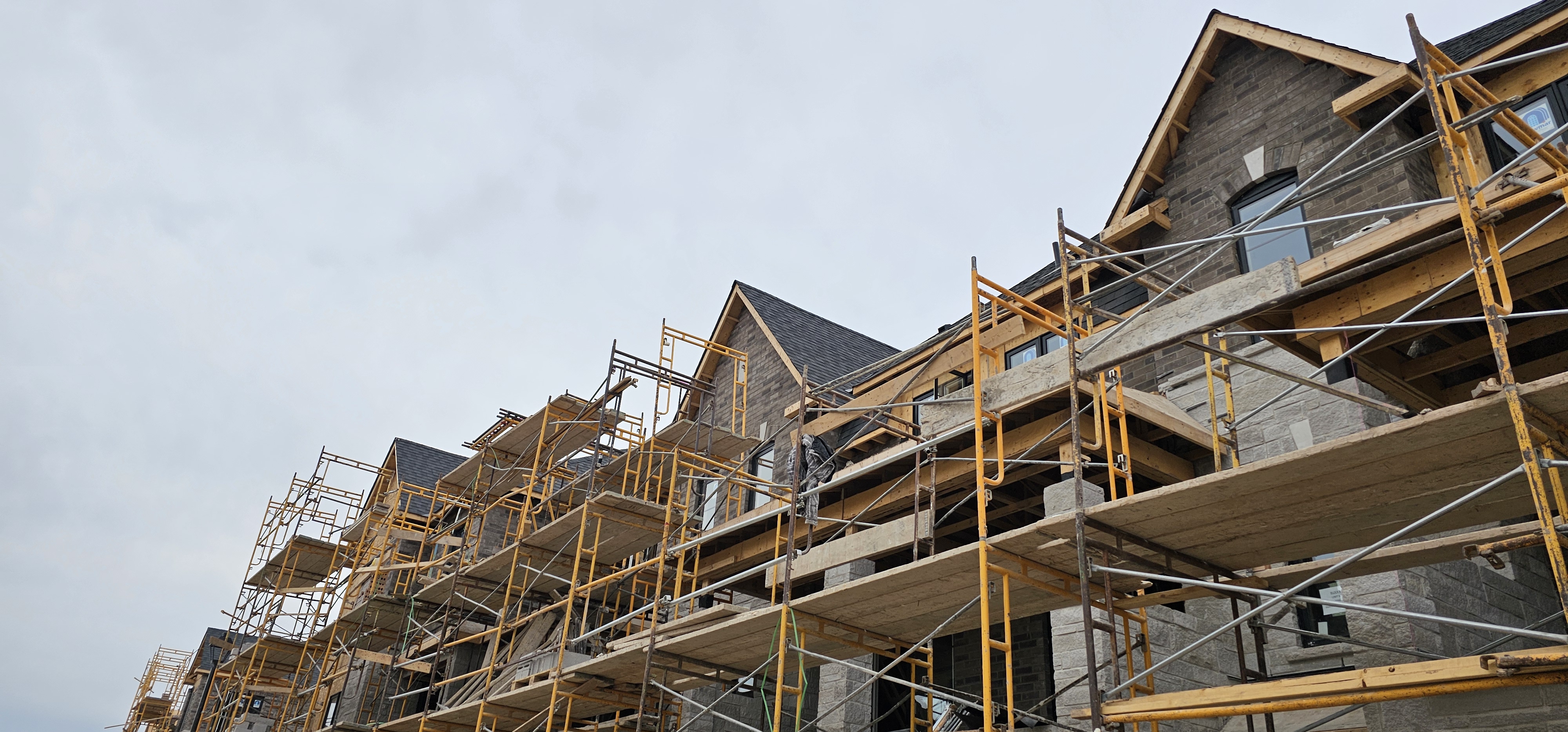 Brick townhomes under construction with scaffolding in Etobicoke, GTA — Olprrix Services